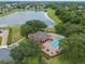 Aerial shot of the community pool, hot tub, and clubhouse near a serene lake in a leafy neighborhood at 2456 Northumbria Dr, Sanford, FL 32771