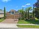 Beautiful two-story home with manicured lawn, mature trees, three car garage and paver driveway at 2456 Northumbria Dr, Sanford, FL 32771