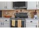 Updated kitchen featuring stainless steel appliances, tile backsplash, and white cabinets at 2456 Northumbria Dr, Sanford, FL 32771