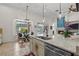 Bright kitchen island with a view of the living room fireplace, outdoor dining area, and modern decor at 2456 Northumbria Dr, Sanford, FL 32771