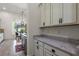 Kitchen featuring granite countertops, white cabinets, and a view of the outdoor patio and dining area at 2456 Northumbria Dr, Sanford, FL 32771