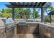 View of outdoor kitchen under a pergola, featuring stainless steel grill and counter space at 2456 Northumbria Dr, Sanford, FL 32771