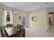 Dining room with large window, decorative chandelier, and access to other areas of the home at 2626 Coachman Dr, Deltona, FL 32738