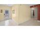 Hallway with tile flooring, neutral walls, leading to a bathroom and ornate front door at 2626 Coachman Dr, Deltona, FL 32738