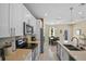 Bright kitchen featuring white cabinets, quartz countertops, stainless steel appliances and open to dining area at 2626 Coachman Dr, Deltona, FL 32738