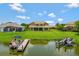 Aerial view of a house with a manicured lawn, boat docks, and lake access creating an outdoor lifestyle at 2631 Captains Ct, Kissimmee, FL 34746