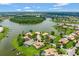 Community aerial featuring lush greenery, lakeside homes, and serene waterways with a tree island at 2631 Captains Ct, Kissimmee, FL 34746