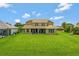 Expansive backyard showcasing lush greenery, a screened-in lanai, and a well-maintained lawn at 2631 Captains Ct, Kissimmee, FL 34746