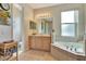 Full bathroom featuring a bathtub, a double-sink vanity, tiled floors, and a window for natural light at 2631 Captains Ct, Kissimmee, FL 34746