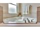 Bright bathroom featuring a corner bathtub with tile surround and a towel rack near a window at 2631 Captains Ct, Kissimmee, FL 34746