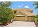 Beautiful two-story home featuring a neutral color scheme, tile roof, manicured landscaping, and a brick paver driveway at 2631 Captains Ct, Kissimmee, FL 34746