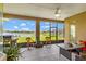 Enclosed lanai offers views of a lake and dock, complete with seating, grill, and ceiling fan at 2631 Captains Ct, Kissimmee, FL 34746