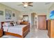 Well-lit main bedroom featuring tile flooring, a king bed, and ensuite bathroom, ideal for relaxation at 2631 Captains Ct, Kissimmee, FL 34746