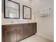 Bathroom with double sink vanity, dark wood cabinets, and large mirrors for added space at 2745 Corvette Ln, Kissimmee, FL 34746