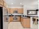 Fully equipped kitchen with stainless steel appliances and wooden cabinets, adjacent to dining area at 2745 Corvette Ln, Kissimmee, FL 34746