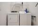 Bright laundry room features a washer, dryer, and overhead shelving for storage at 2745 Corvette Ln, Kissimmee, FL 34746