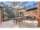 Relaxing screened-in patio featuring a hot tub, dining area, and comfortable seating at 2745 Corvette Ln, Kissimmee, FL 34746