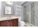 Bright bathroom with updated tile shower, marble vanity, and white shelves for optimal storage at 300 Florida Pkwy, Kissimmee, FL 34743
