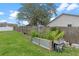 Landscaped backyard featuring a wooden fence, mature trees, and a metal raised garden bed at 3235 Utah Dr, Deltona, FL 32738