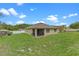 Expansive backyard with green grass, screened lanai, and surrounding trees at 3235 Utah Dr, Deltona, FL 32738