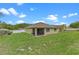 View of the backyard features a green lawn, fence, and a glimpse of the home's screened-in porch at 3235 Utah Dr, Deltona, FL 32738