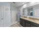 Bright bathroom with a double vanity, walk-in shower, and a large mirror that creates an open feel at 3235 Utah Dr, Deltona, FL 32738