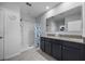 Bright bathroom featuring a shower, a double sink vanity, and neutral-toned tile flooring at 3235 Utah Dr, Deltona, FL 32738