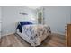 Welcoming bedroom offers wood-look flooring, light blue walls, and a comfortable bed with blue accents at 3235 Utah Dr, Deltona, FL 32738