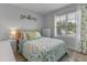Bright bedroom with a plush bed, a large window with leafy curtains, and a light-colored nightstand and dresser at 3235 Utah Dr, Deltona, FL 32738