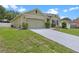Charming single-story home with a well-manicured lawn, concrete driveway, and an attached two-car garage at 3235 Utah Dr, Deltona, FL 32738