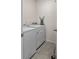 Laundry room equipped with a white washer and dryer, tile floors, and ironing board at 3235 Utah Dr, Deltona, FL 32738