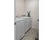 Bright laundry room with white washer and dryer, tile floors, and ironing board at 3235 Utah Dr, Deltona, FL 32738