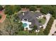 A sprawling estate with manicured grounds, a dark roof, and a backyard pool at 3428 Chaine Du Lac Blvd, Windermere, FL 34786