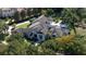 An aerial view of a luxurious estate with a pool, lush landscaping, and mature trees at 3428 Chaine Du Lac Blvd, Windermere, FL 34786
