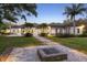 Expansive backyard featuring a stone fire pit, lush lawn, and a view of the home with an inviting pool area at 3428 Chaine Du Lac Blvd, Windermere, FL 34786