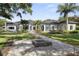 A spacious backyard with a stone fire pit, manicured lawn, and mature trees at 3428 Chaine Du Lac Blvd, Windermere, FL 34786