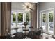 Dining room with modern chandelier, large windows overlooking the pool, and patio access at 3428 Chaine Du Lac Blvd, Windermere, FL 34786