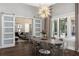 Modern dining room with statement chandelier, with an open view to the living room at 3428 Chaine Du Lac Blvd, Windermere, FL 34786