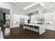 Bright kitchen featuring a large island, stainless steel appliances, and dark hardwood floors at 3428 Chaine Du Lac Blvd, Windermere, FL 34786