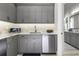 Functional kitchenette featuring gray cabinetry, stainless steel appliances, and a sleek countertop for easy meal prep at 3428 Chaine Du Lac Blvd, Windermere, FL 34786