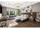 Spacious main bedroom featuring hardwood floors, large windows with seating, and a stylish chandelier at 3428 Chaine Du Lac Blvd, Windermere, FL 34786
