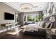 Spacious main bedroom featuring hardwood floors, large windows with seating, and a stylish chandelier at 3428 Chaine Du Lac Blvd, Windermere, FL 34786