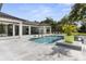 Stunning backyard pool area with a modern design, featuring lounge seating, and lush landscaping, perfect for relaxation at 3428 Chaine Du Lac Blvd, Windermere, FL 34786