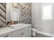 Chic powder room featuring a modern vanity, patterned wall, and contemporary fixtures at 3428 Chaine Du Lac Blvd, Windermere, FL 34786
