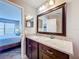 Bathroom featuring granite counters, dark wood cabinets, decorative mirror and view into bedroom at 3944 Atrium Dr # 4, Orlando, FL 32822