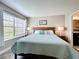 Bedroom featuring wood-style floors, a bright window with blinds, and simple neutral decor at 3944 Atrium Dr # 4, Orlando, FL 32822