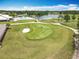 Golf course aerial view of the green and putting green with the lake and community pool in the background at 3944 Atrium Dr # 4, Orlando, FL 32822