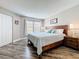 Bright main bedroom with wood-look flooring and a large window featuring an open closet and en-suite bathroom at 3944 Atrium Dr # 4, Orlando, FL 32822