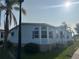 Exterior view of a light blue house featuring a well-manicured lawn, a driveway, and a palm tree at 622 Dreama Dr, Davenport, FL 33897