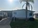 Charming home features a well-maintained lawn, a palm tree, and light blue siding with blue shutters at 622 Dreama Dr, Davenport, FL 33897